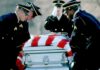 Honor guard carrying a flag-draped casket