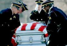 Honor guard carrying a flag-draped casket