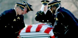 Honor guard carrying a flag-draped casket