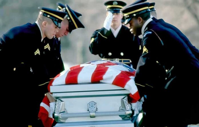 Honor guard carrying a flag-draped casket