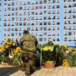 9/11 Families Revolt: Muslim Mayor Told to STAY AWAY Soldier kneels at memorial wall with photos and flowers