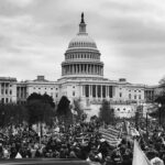 U.S. Capitol building with large crowd and flags