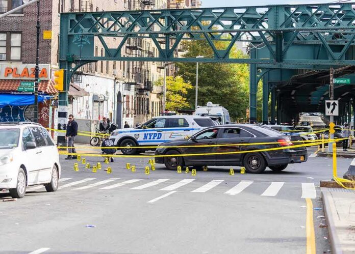 shutterstock_2214792785 Police cars block a city intersection with yellow crime scene tape