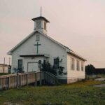 Dem Candidate ADMITS To Harboring Illegals Small white church with steeple and cross at sunset