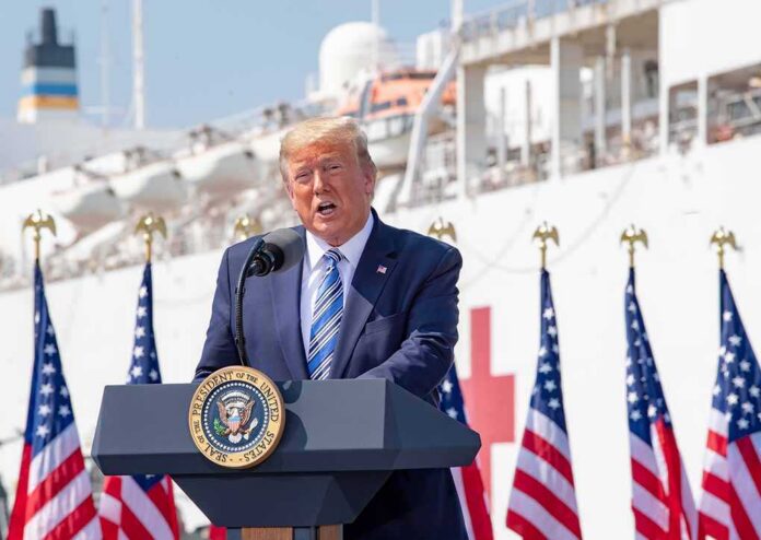 Donald Trump speaking at a podium with American flags and a ship in the background