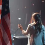 American flag and speaker at podium addressing audience