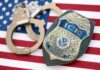 ICE officer badge and handcuffs on an American flag