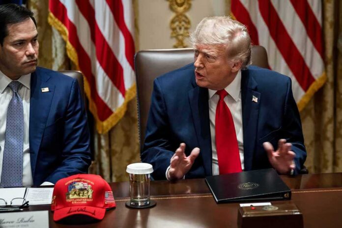 Man in suit with red tie speaks at meeting table