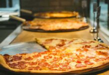 Pepperoni pizza slices on metal trays