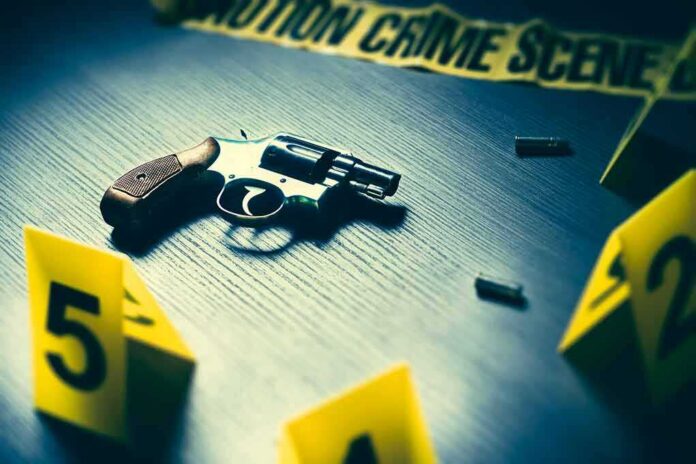 shutterstock_616493339 Revolver on a table at a crime scene with evidence markers