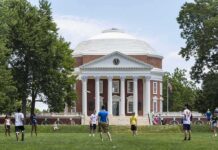 Students playing on a lawn in front of a domed neoclassical building