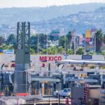 Border crossing booths at Mexico entry point with cityscape in background