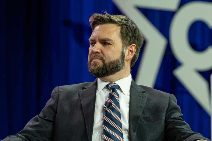 Man in suit with striped tie sitting on stage