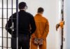 Police Officers ARRESTED – Abusing Flock Cameras, Looking Up Teens Prisoner in orange jumpsuit handcuffed and escorted by officer