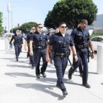 Officers DEAD After Midnight Ambush! Police officers walking in formation on a city sidewalk