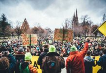 France Brings In Army – Barbaric Protestors UNCONTROLLABLE Christian Jones at a large outdoor protest with crowds and handmade signs