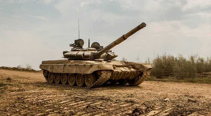shutterstock_1431516980 Main battle tank on muddy terrain with elevated gun barrel