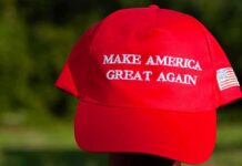 Red baseball cap with political slogan and small U.S. flag patch