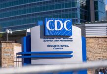 Ebola Spreads – Widest Outbreak in History CDC headquarters sign outside modern office buildings