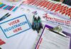 Serial Noncitizen Voters Indicted: Some Cast Ballots for Decades! Voter registration table with forms, pens, and informational materials