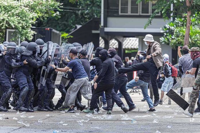 Protesters clash with riot police holding shields