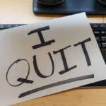 Paper note reading I QUIT on a computer keyboard