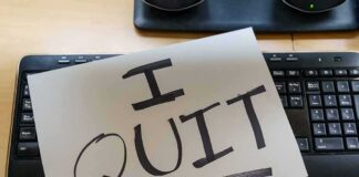 Paper note reading I QUIT on a computer keyboard