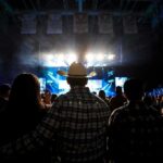 Bomb Threat Halts Sold-Out Ella Langley Concert Cowboy-hatted man watches a concert in a packed arena