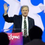 GOP Senators Presidential Ultimatum Rattles 2028 John Neely Kennedy waves while speaking at a podium on a brightly lit stage