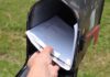 Hand retrieving mail from an open rural mailbox