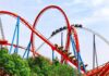 Colorful roller coaster with riders on a sunny day