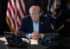 Trump Blasts GOP Senator in Late-Night Attack Donald Trump seated at a table between two desk phones