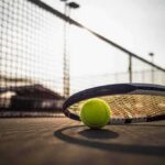 Highest Paid Athlete in World Says It’s Hard Being a Black in the US Tennis racket and ball on a court near the net