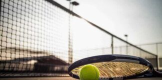 Tennis racket and ball on a court near the net