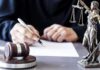 Body Armor Ban Ruled Unconstitutional – Major 2A Win Judge writing at desk with gavel and Lady Justice statue