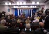 Trump Judge Hands Media Indefinite White House Access Press secretary at podium addressing reporters in briefing room